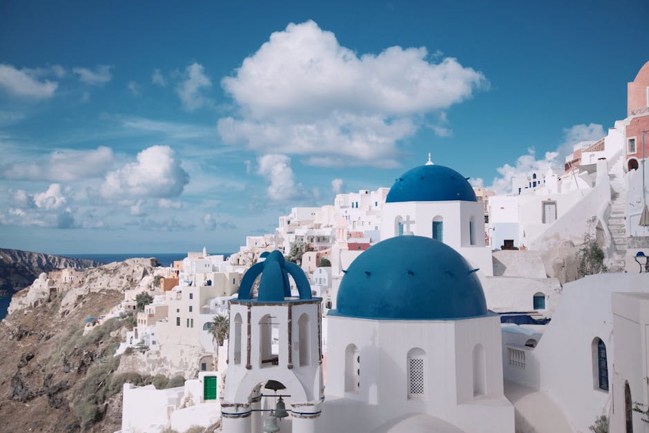 Breathtaking view of Oia's iconic blue-domed churches against a vibrant sky in Santorini, Greece