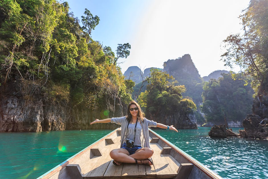 Asian woman relishing a serene boat journey through the lush karst landscape of Thailand's Khlong Sok